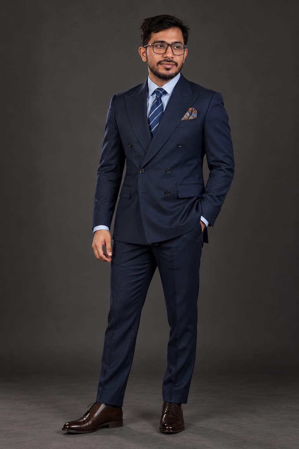 Muhsin Ullal standing in a tailored navy suit
